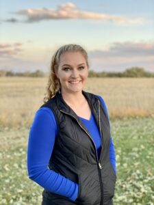Picture of Annelyse in a field with mountains in background